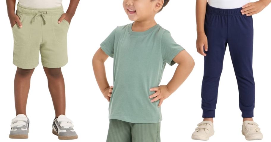 a toddler boy smiling wearing a green t-short and kids with pants and shorts around him