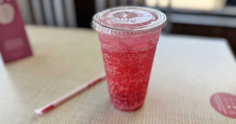 pink drink in a plastic to-go cup on a restaurant table