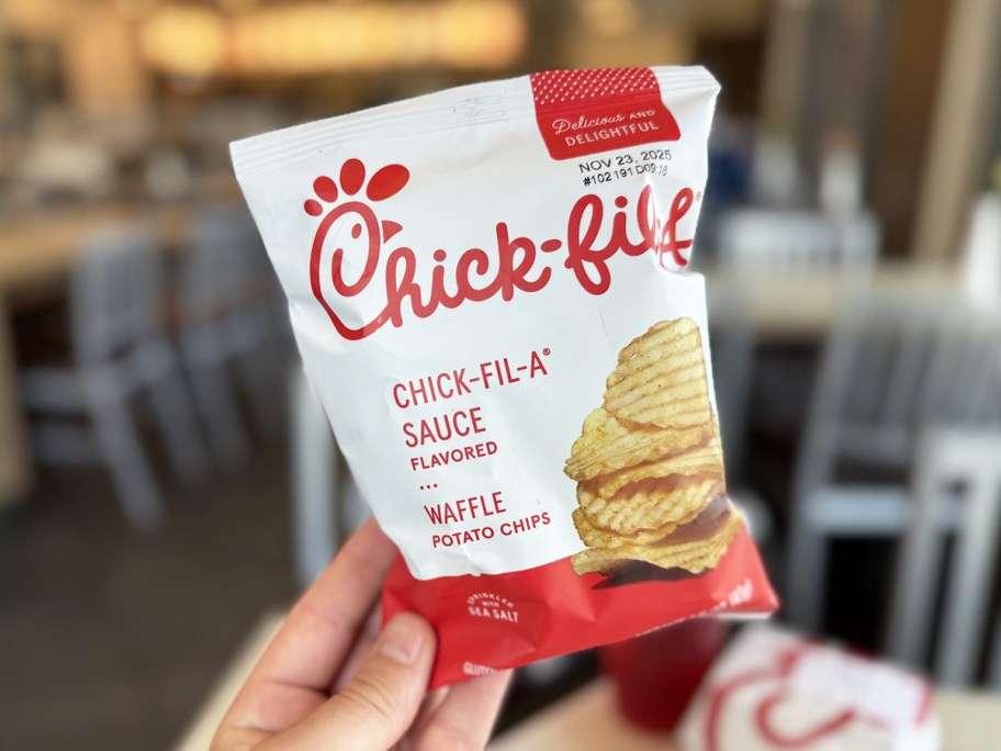 hand holding up a bag of Chick-fil-A Sauce flavored Waffle Potato Chips