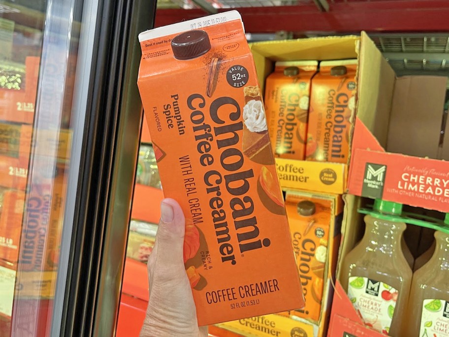 hand holding an orange carton of Chobani Pumpkin Spice Coffee Creamer