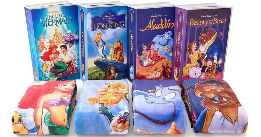 Several large VHS covers with Disney throw blankets in front of them