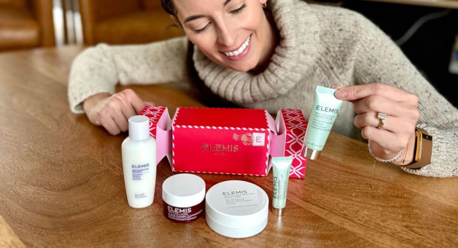 woman holding Elemis skincare hand holding thats displyed on the table