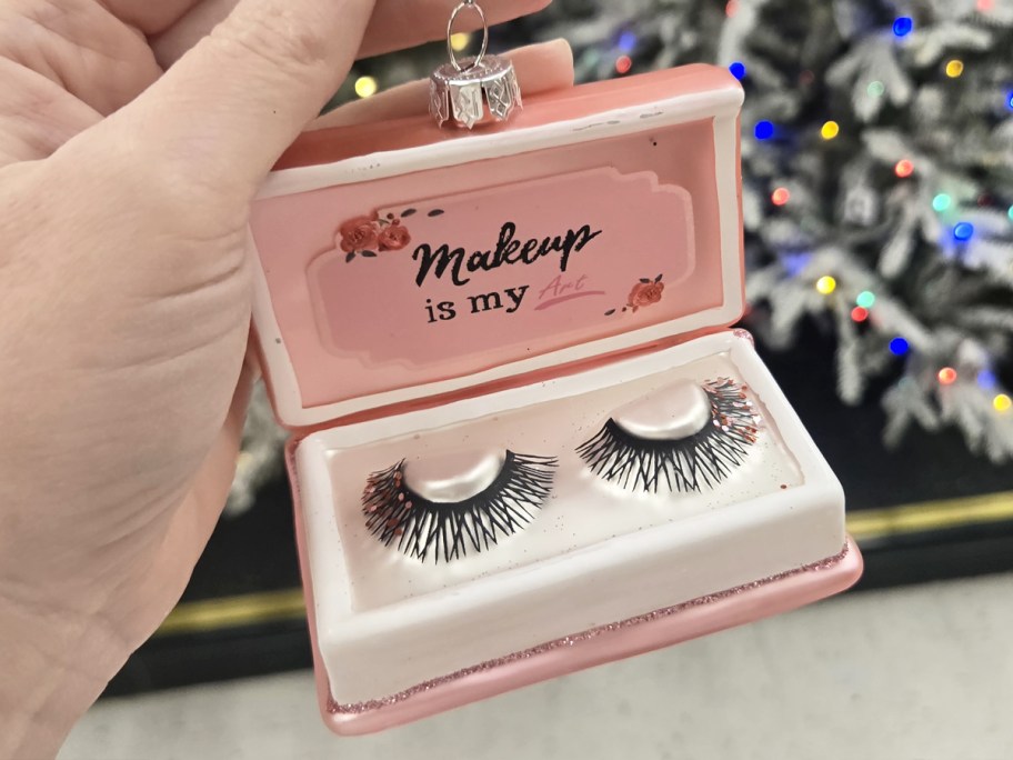 hand holding up a false eyelashes set ornament