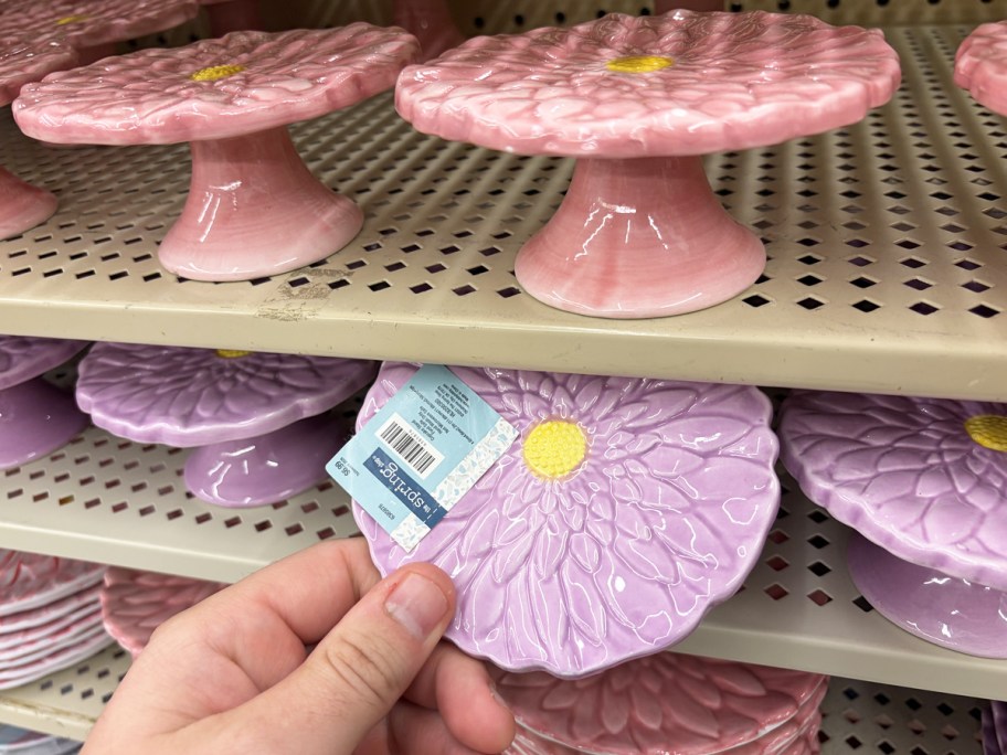 hand grabbing a purple Flower Cupcake Stand from store shelf
