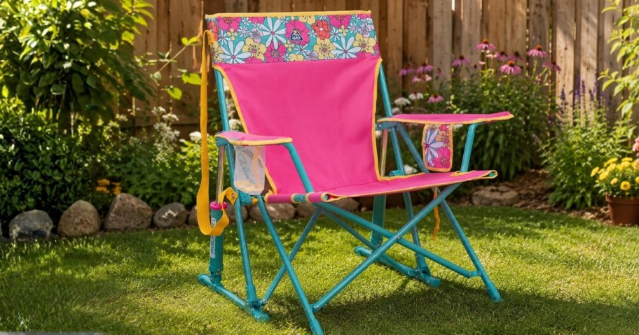 a pink and green floral outdoor rocker chair in a backyard