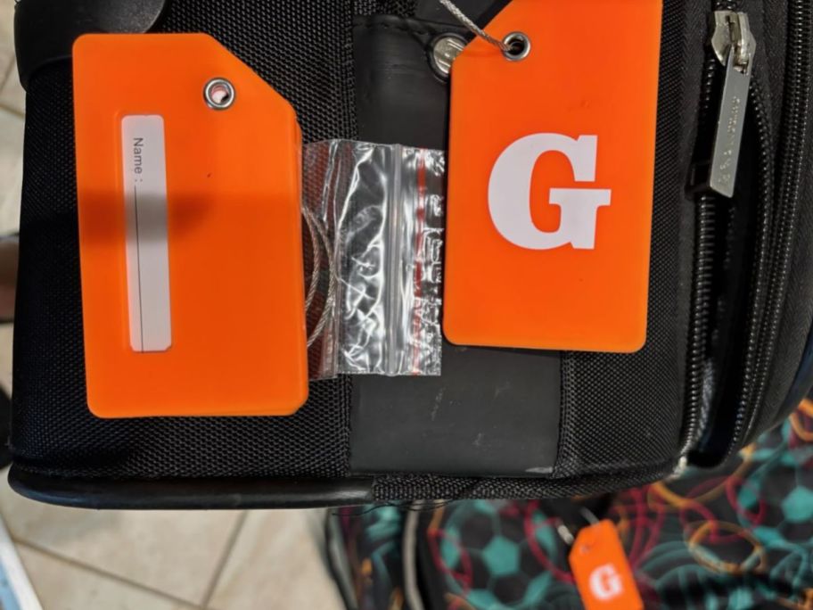 orange luggage tags attached to luggage