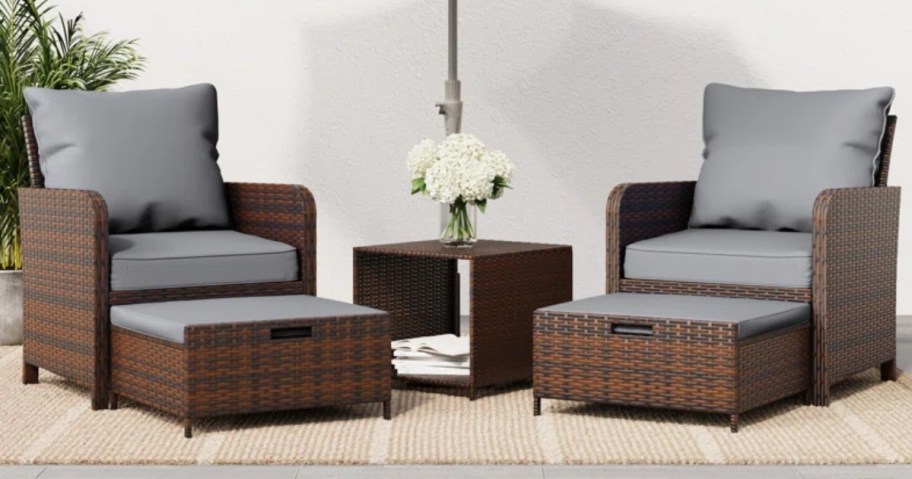 a wicker outdoor set with 2 chairs, ottomans and side table