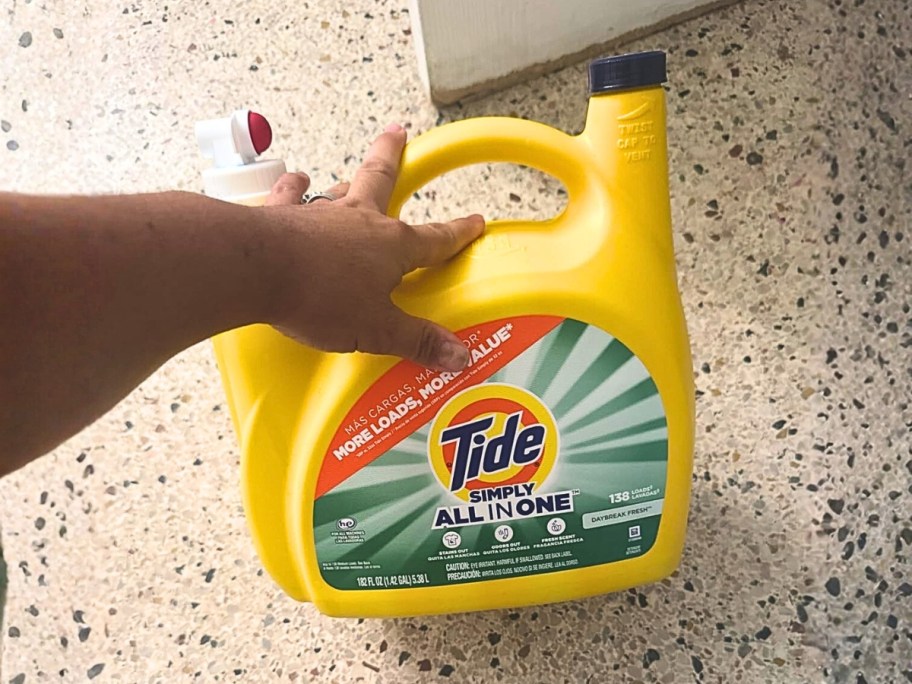 hand on a large Tide Simply laundry detergent jug
