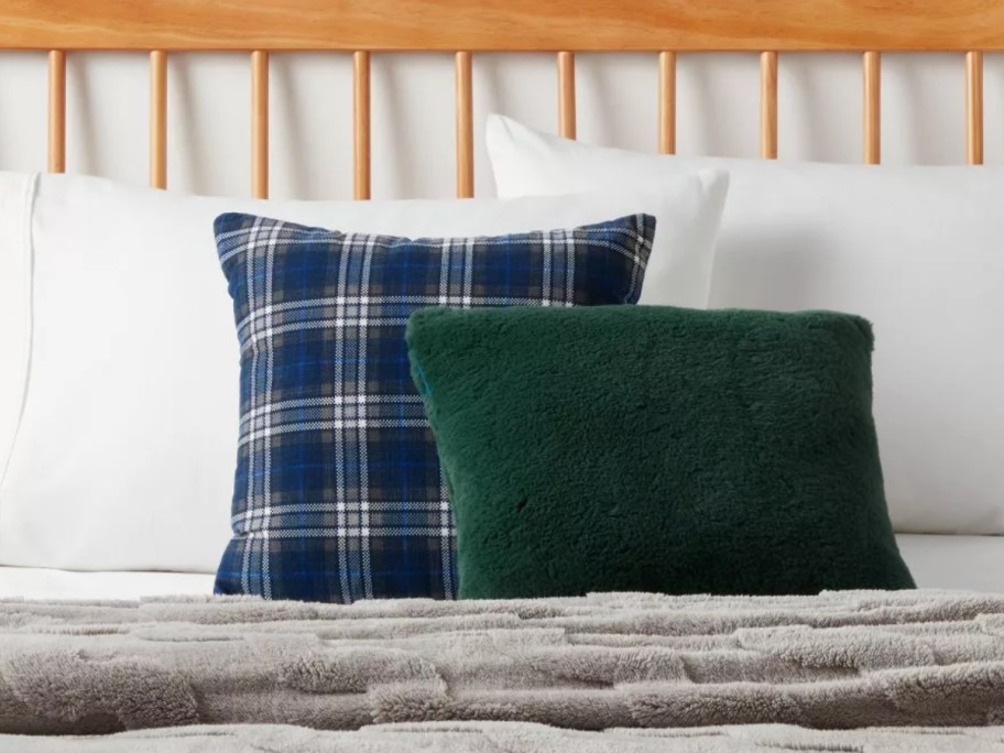 a blue plaid pillow and a green shearling pillow