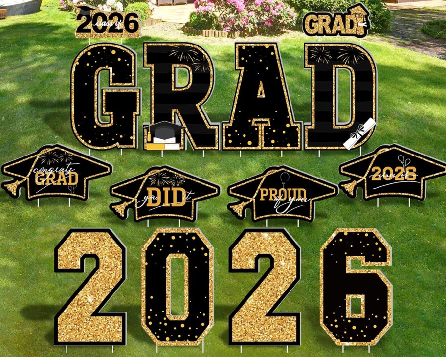 black and gold graduation yard signs on a lawn