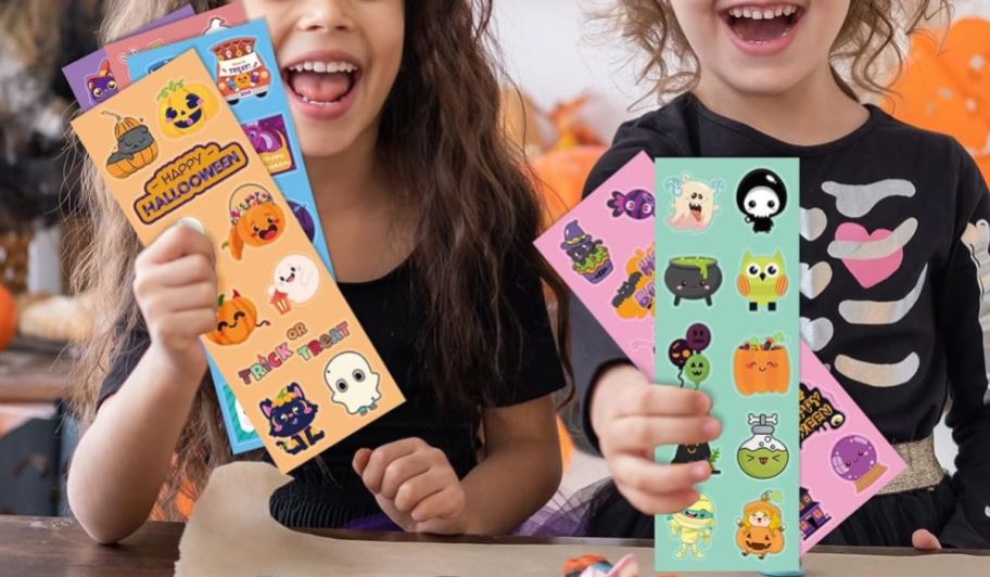 Two girls holding up Halloween sticker packets