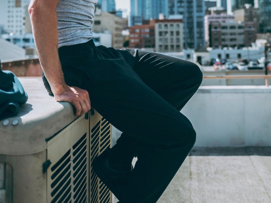 man in grey sweatpants and black pants
