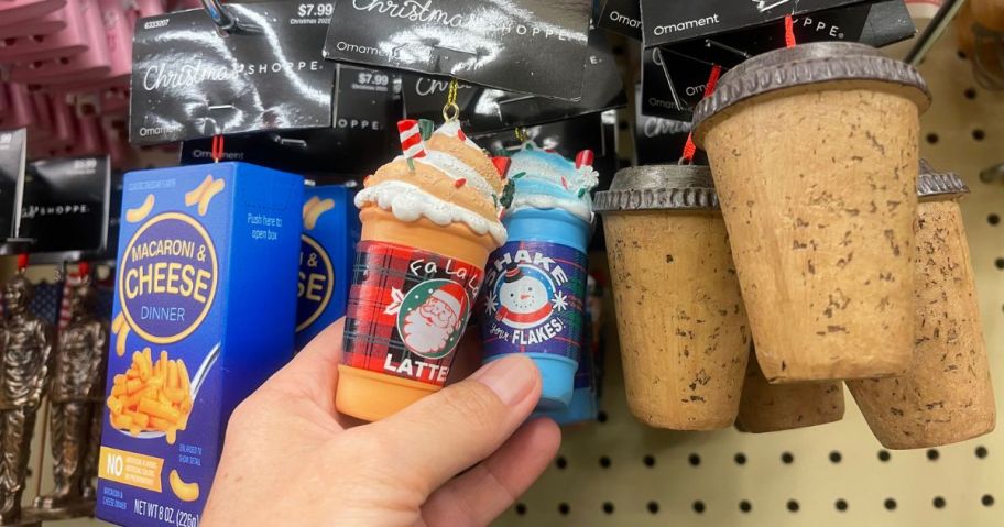 A person holding a latte ornament in a store
