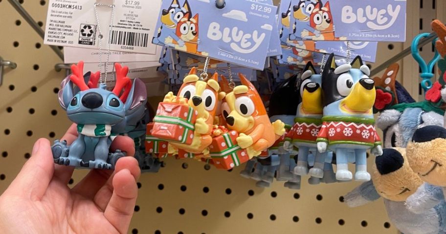 A person holding a Stitch ornament in a store