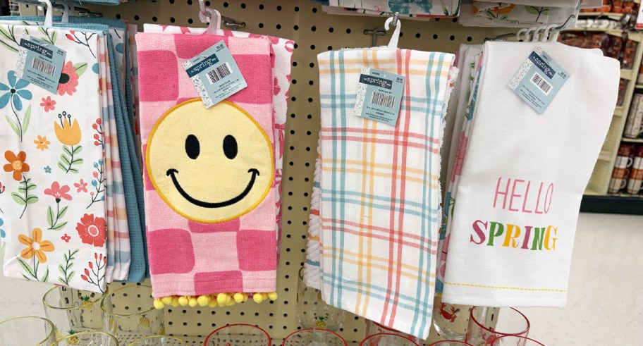 colorful printed kitchen towels hanging from store display rack