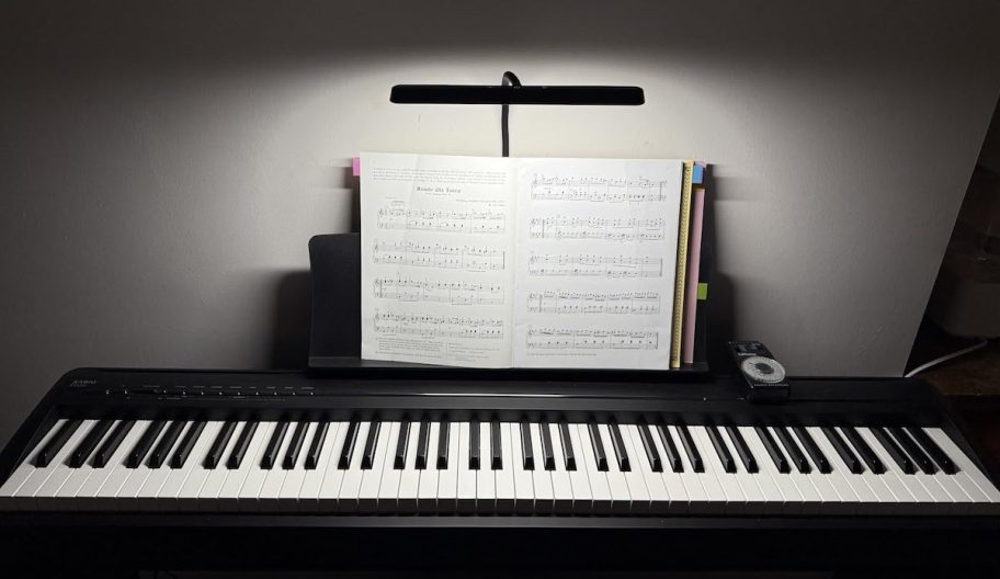 Piano with music notebook and clip light on stand 
