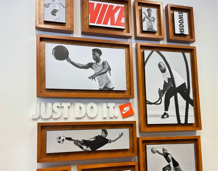 A wall of Black and white sports photos at the Nike outlet with their Just Do It slogan and Logo on the wall.