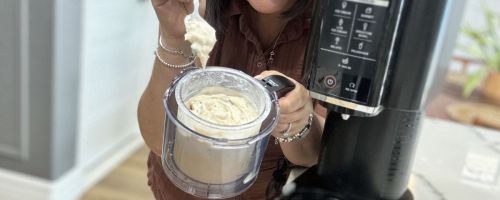 woman holding Ninja creami with ice cream showing in the bowl