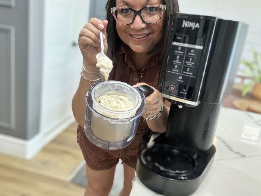 woman holding Ninja creami with ice cream showing in the bowl