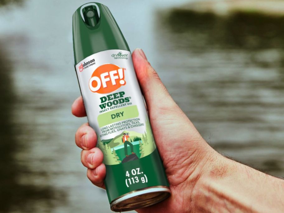 hand holding off wood spray in front of the water