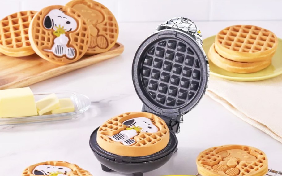 opened mini waffle maker with snoopy and woodstock waffle on it