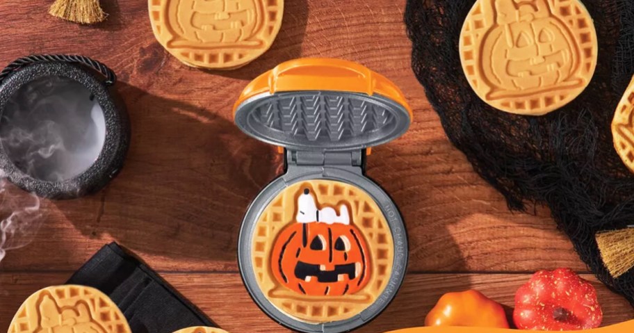 opened mini waffle maker with snoopy on a pumpkin waffle on it