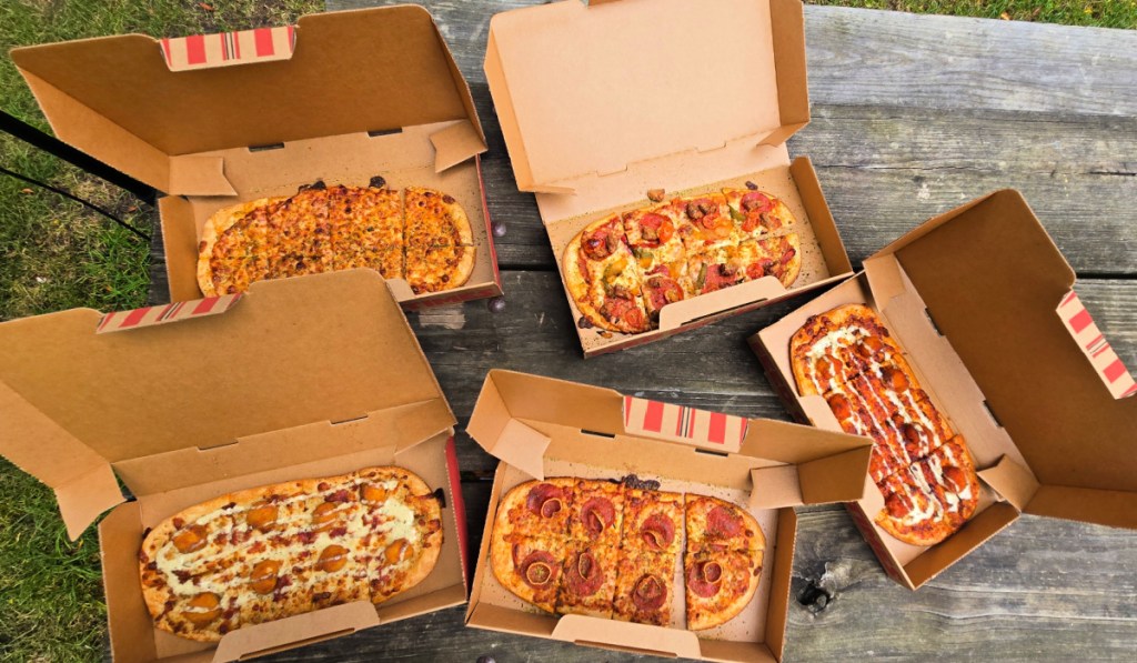 5 different flavors of Pizza Hut Flatzz on wooden table