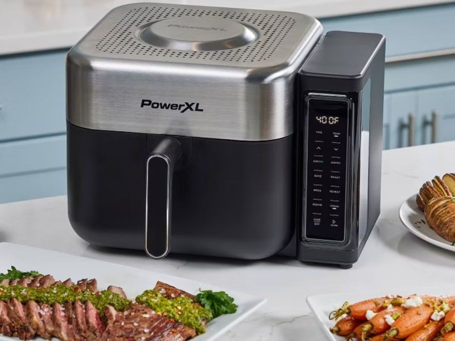 PowerXL airfryer with food around it on top of the table 