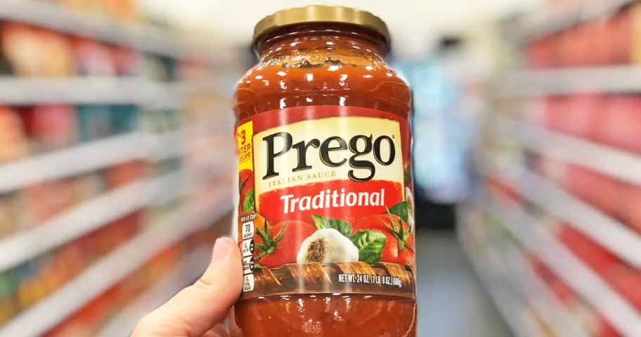hand holding a jar of Prego Pasta Sauce in store