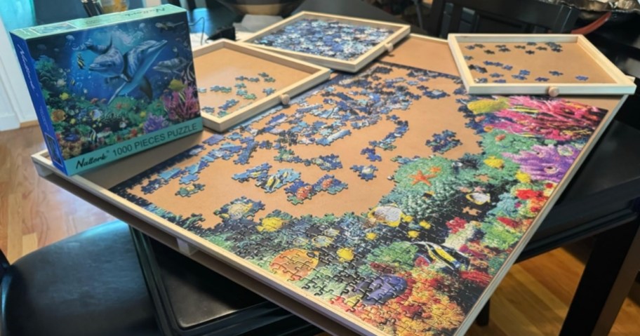 puzzle table with sea themed puzzle pieces and drawers on table