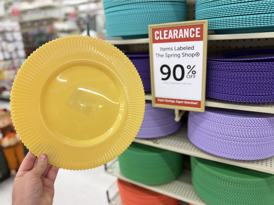 hand holding up a yellow Ribbed Charger Plate next to a 90% off sale sign