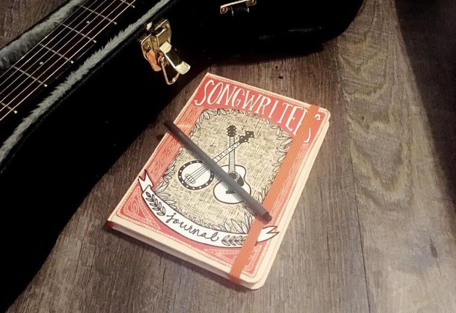 Songwriter's Journal sitting next to guitar case 