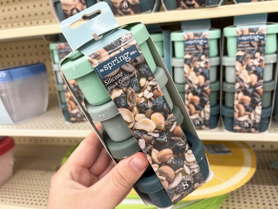 hand holding up a set of green snack containers