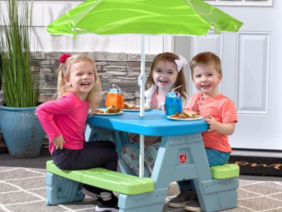 kids sitting at a picnic table together
