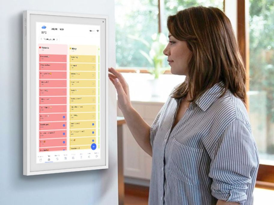 Woman using a Tabwee Digital Calendar that is mounted on a wall