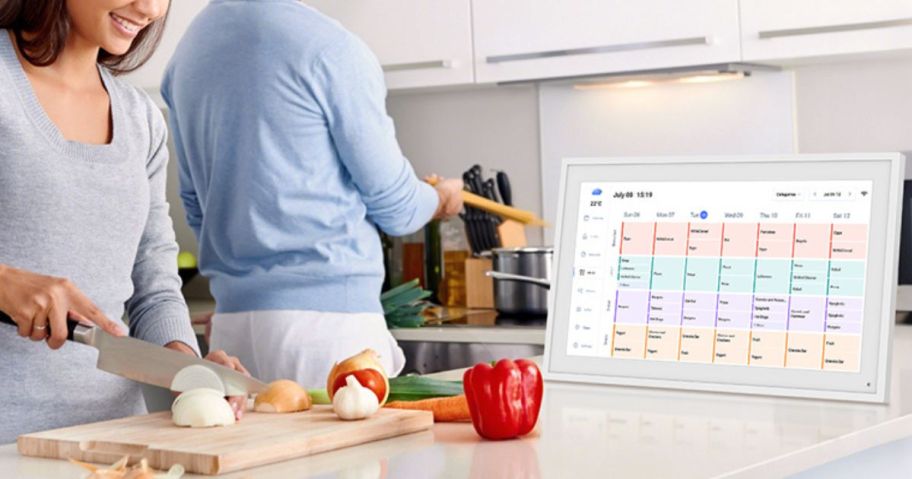 Couple cooking in the kitchen with a Tabwee digital calendar nearby.