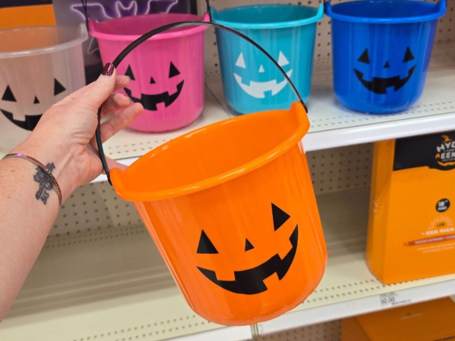 Hand holding an Orange Halloween Bucket at Target