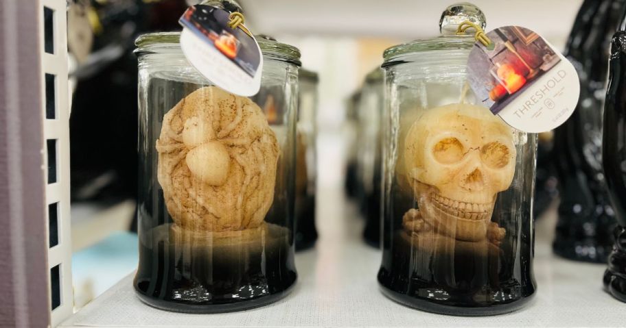 2 figural candles: a spider and a skull under a cloche 