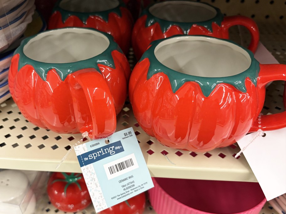 red Tomato-Shaped Mugs on store shelf