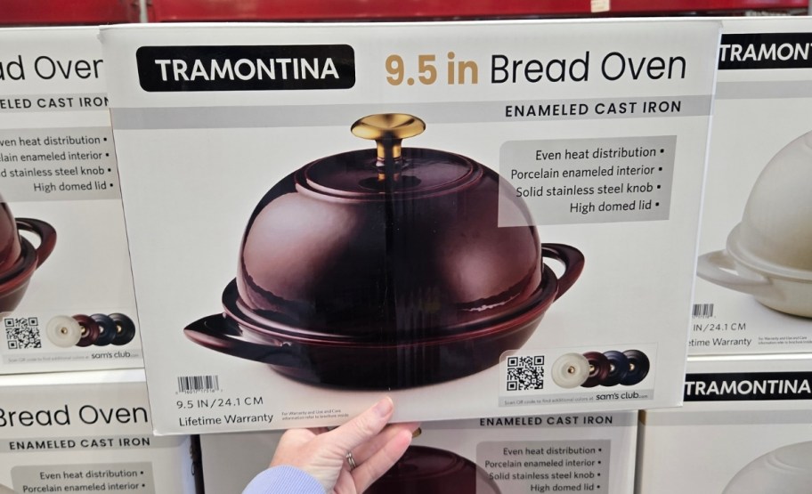 a womans hand grabbing a box with an enameled cast iron bread oven