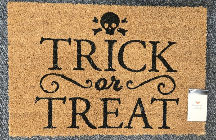 doormat that says trick-or-treat with a black skull at the top