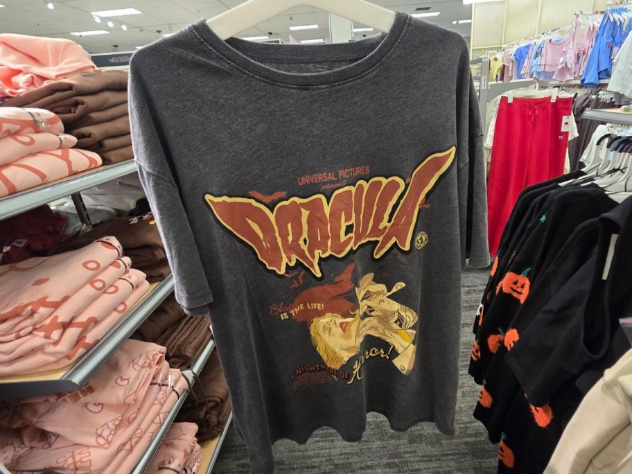 A woman holding a Dracula t-shirt