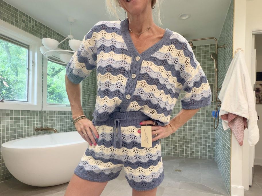 Woman wearing a Universal Threas sweater knit cardigan top and shorts