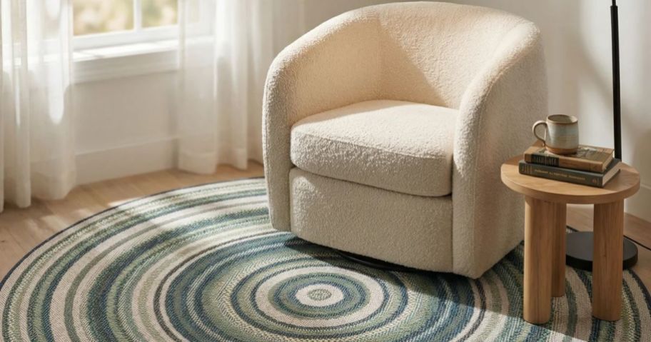 Accent chair and round area rug next to a table with a lamp