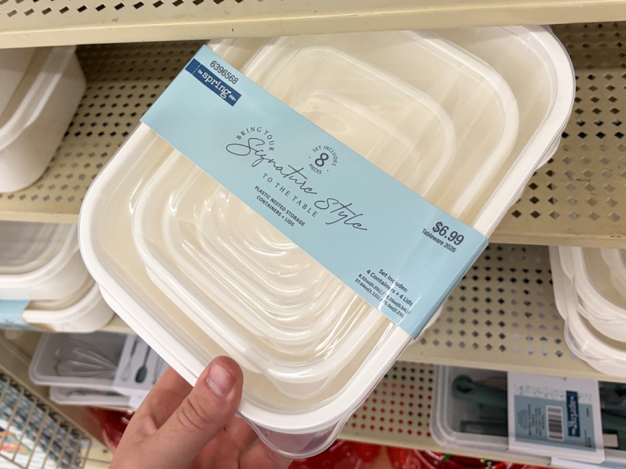 hand grabbing a set of white storage containers from shelf