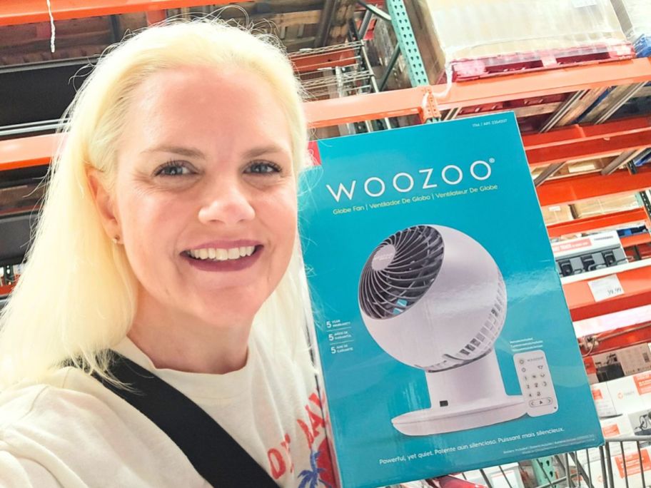 stefanie holding Woozoo 5-Speed Globe Fan box in store