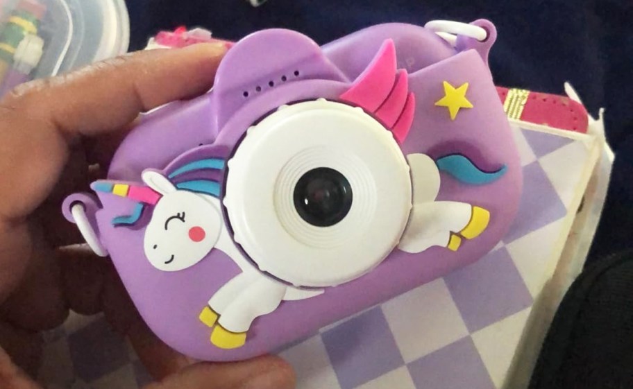 hand holding a purple unicorn kids camera