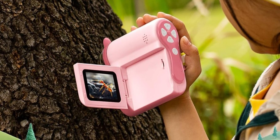 hand holding pink camera/microscope