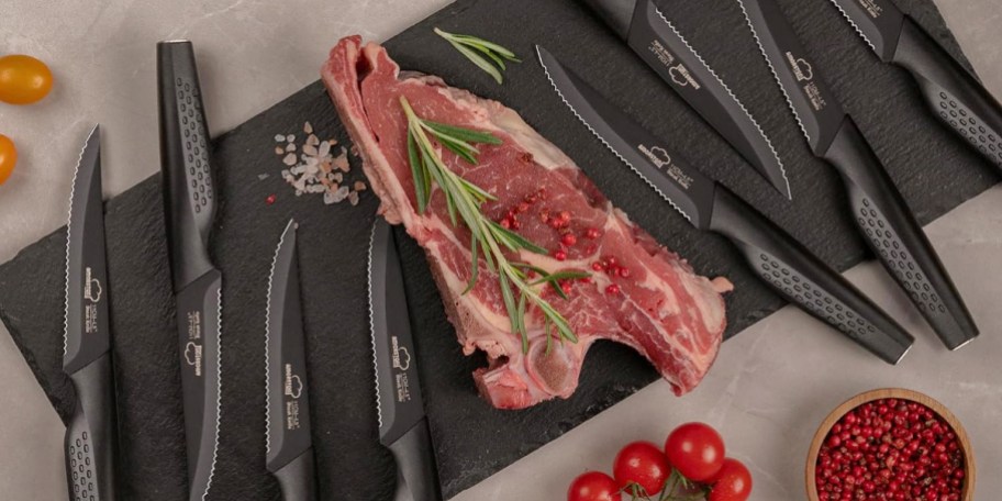 steak on cutting board with 8 knives