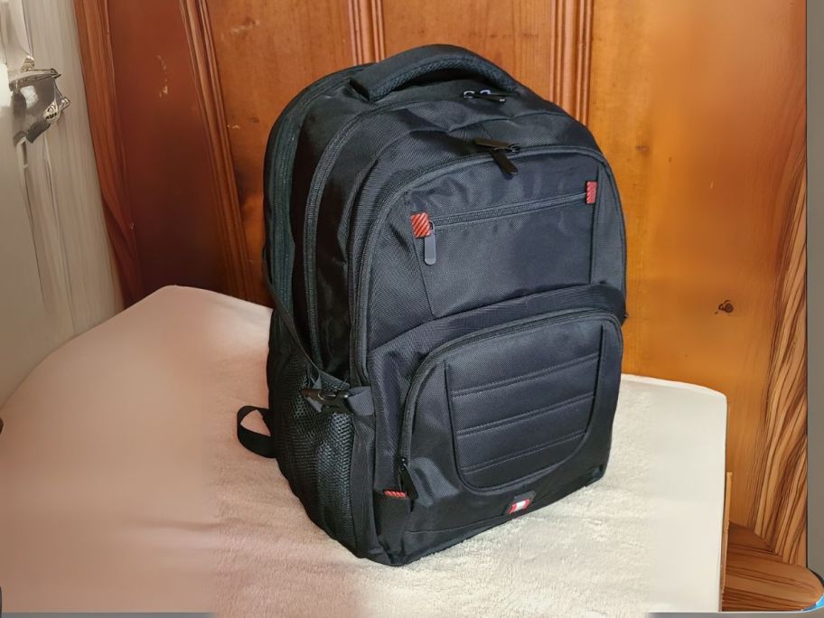 black extra large travel backpack on bench